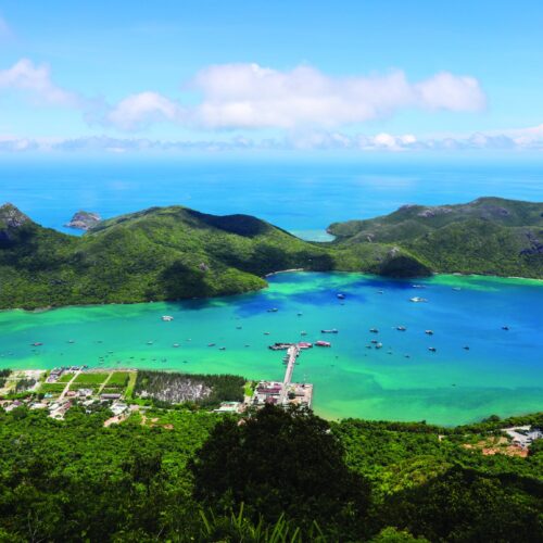 High-angle view of Con Dao coastline, mainland in foreground and a small island at center.