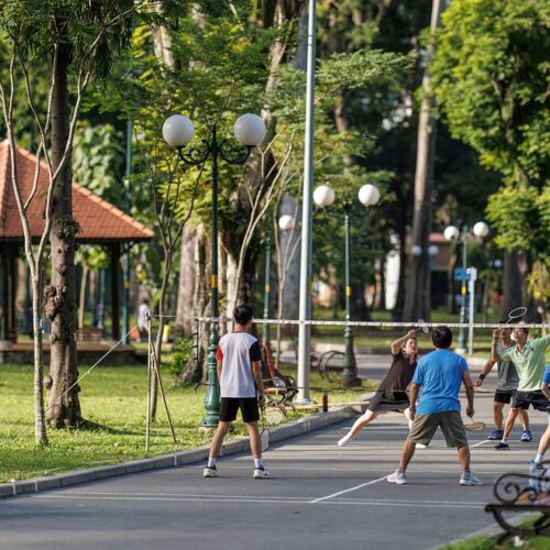 A group of locals playing badminton in Tao Dan Park, enjoying an active morning in Saigon’s green lung in city center.