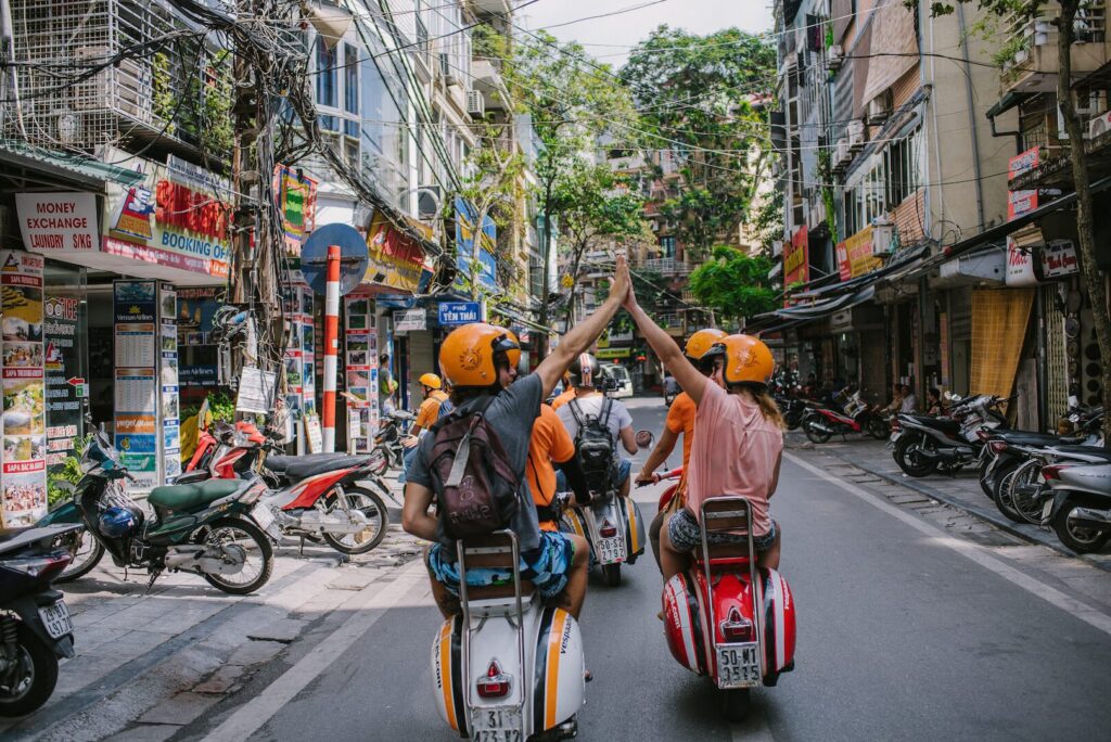 travelers happily enjoy the vintage vespa tour on Hanoi street