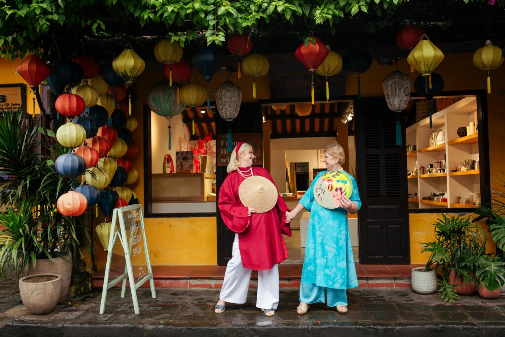 2 women tourists wearing a traditional ao dai in hoi an, viet nam