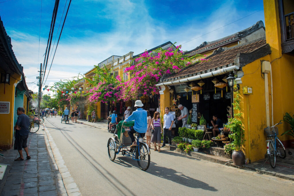 an old man riding a cyclo (xĆch lĆ“) along hoi an road