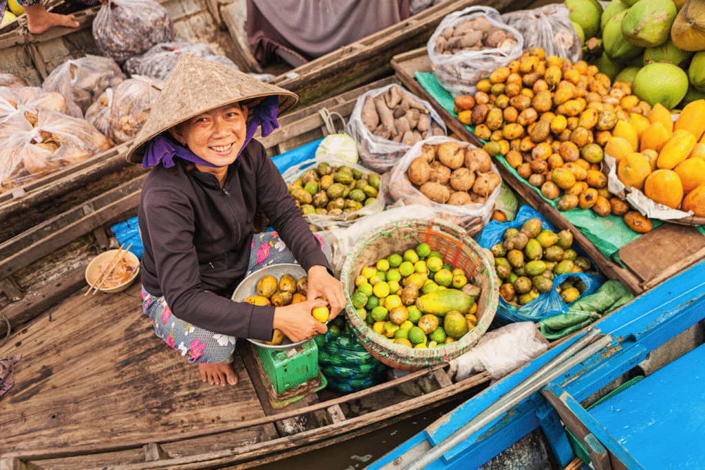 smiling local woman on a fruit boat in Can Tho