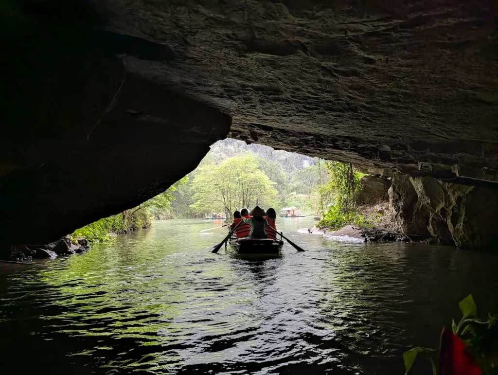 A rowing boats in Trang An, Ninh Binh; which is rowing out of a cave.
