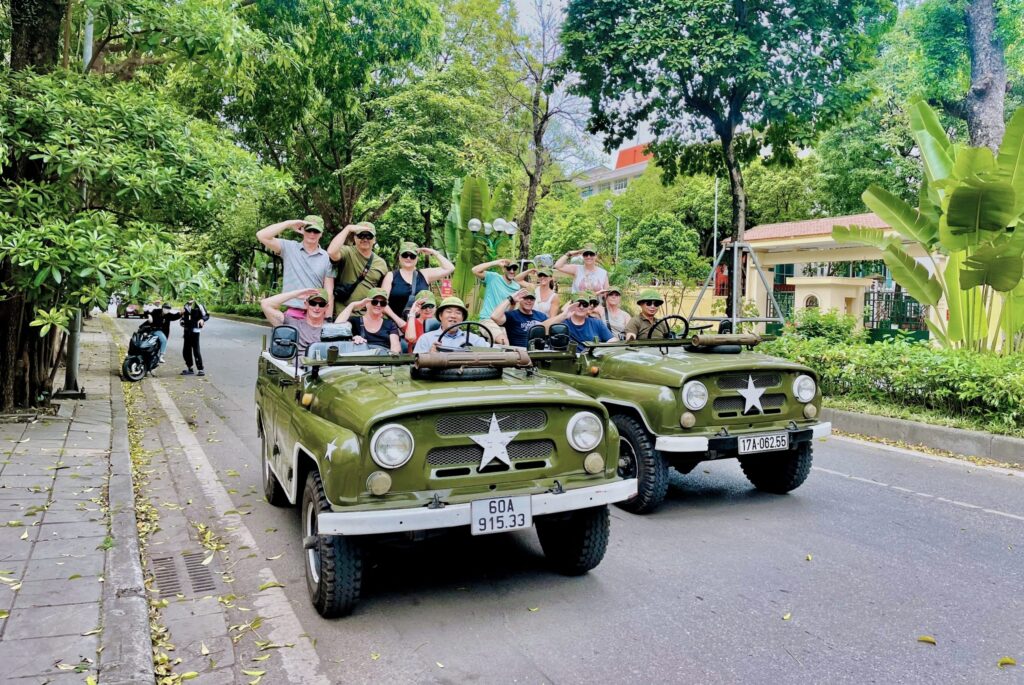 Two jeeps are on a sightseeing tour of Hanoi's streets, with many tourists enjoying.