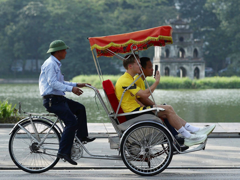 2 travellers is getting around hanoi by cyclo