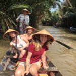 group of female travelers enjoying a rowing boat trip in ben tre