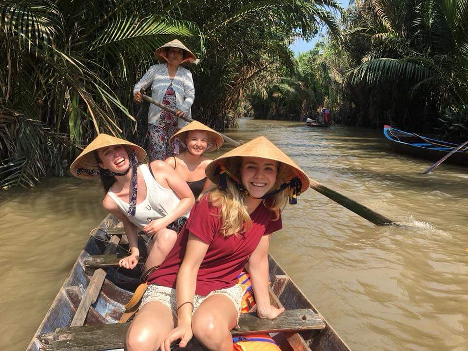 group of female travelers enjoying a rowing boat trip in ben tre